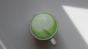a cup of green liquid sitting on top of a table